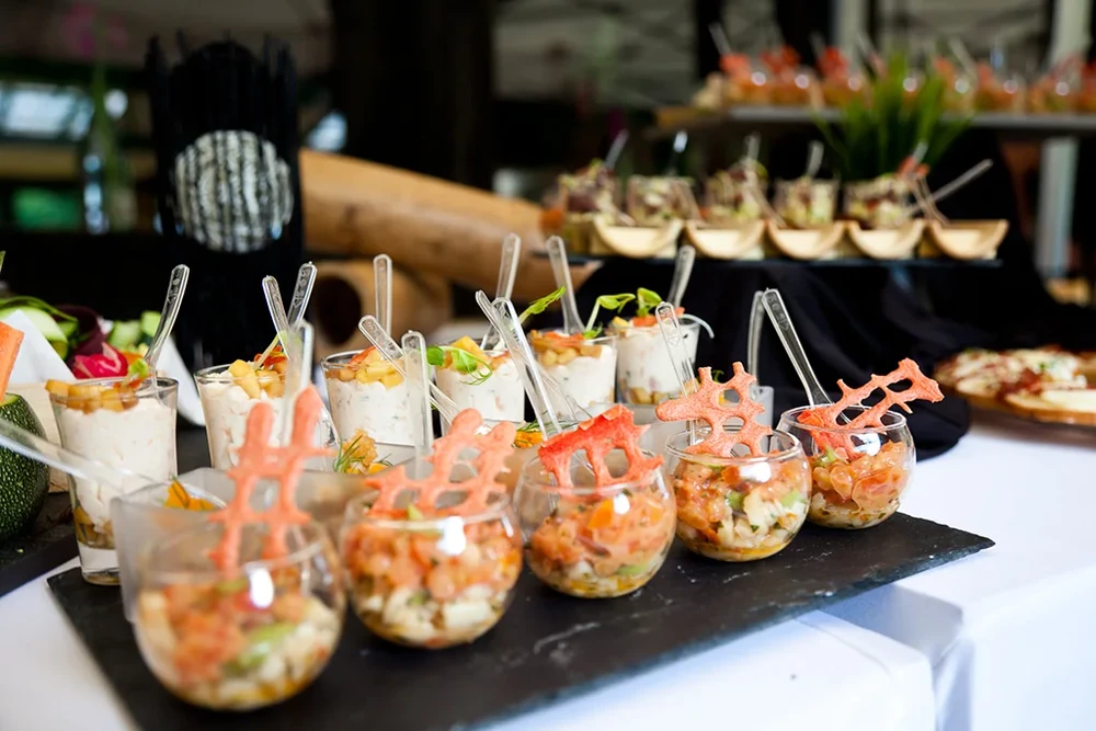 Scène de buffet gastronomique en intérieur avec serveur en arrière-plan