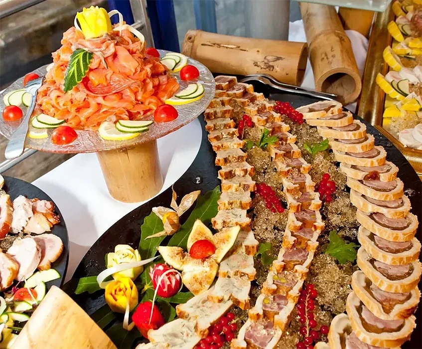 Buffet gastronomique en intérieur avec plateau de charcuterie artisanale sur ardoise noire