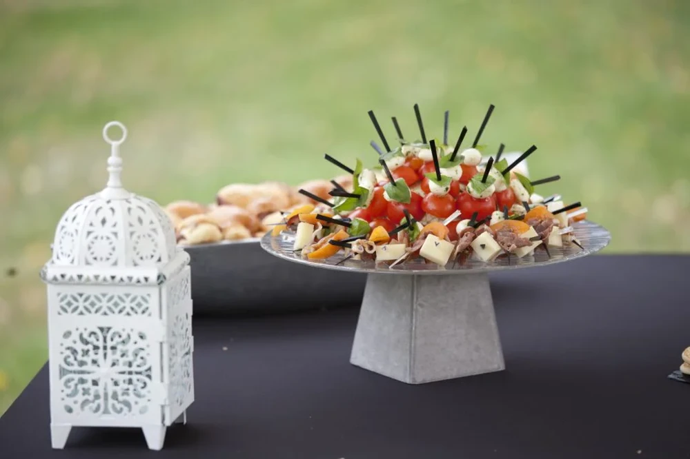 Buffet traiteur élégant disposé sur une terrasse vitrée avec vue sur rivière urbaine