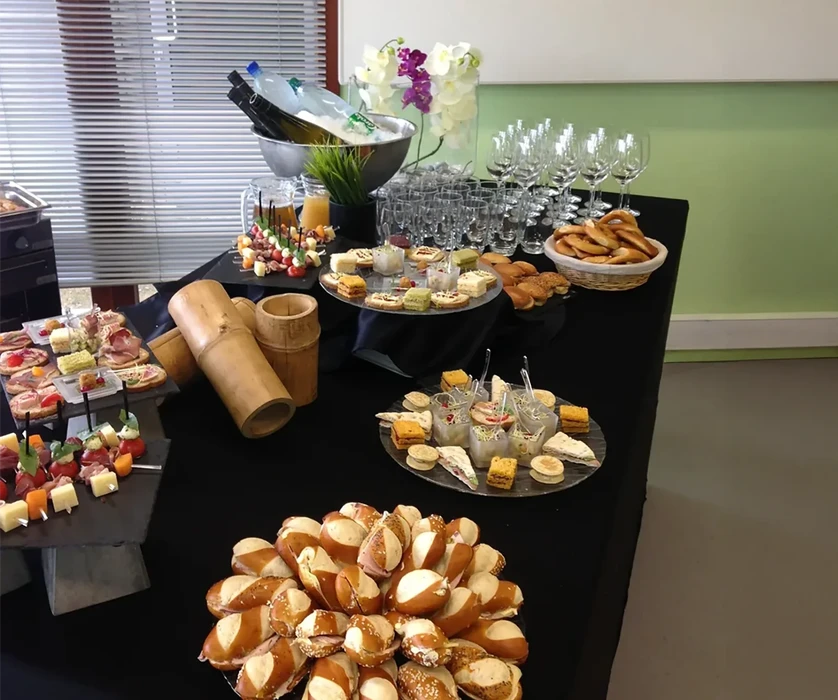 Buffet gastronomique en intérieur avec plateaux de charcuterie et fromages disposés sur comptoir noir