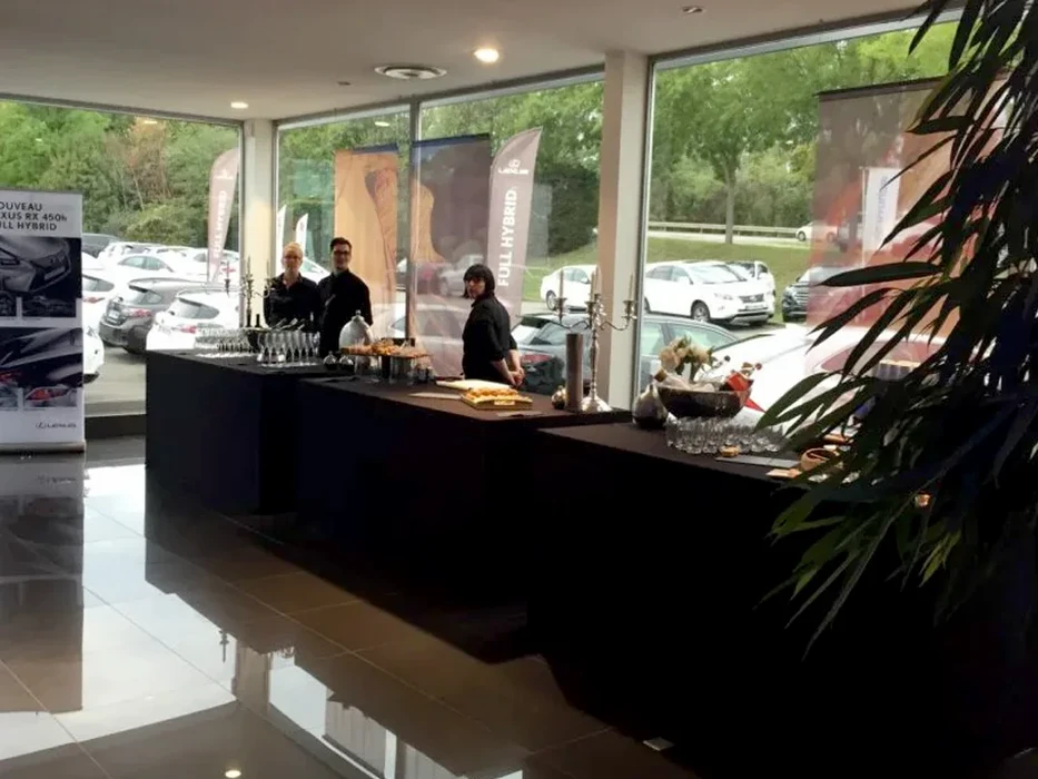 Scène intérieure de service traiteur avec verrines apéritives disposées sur plateau ardoise