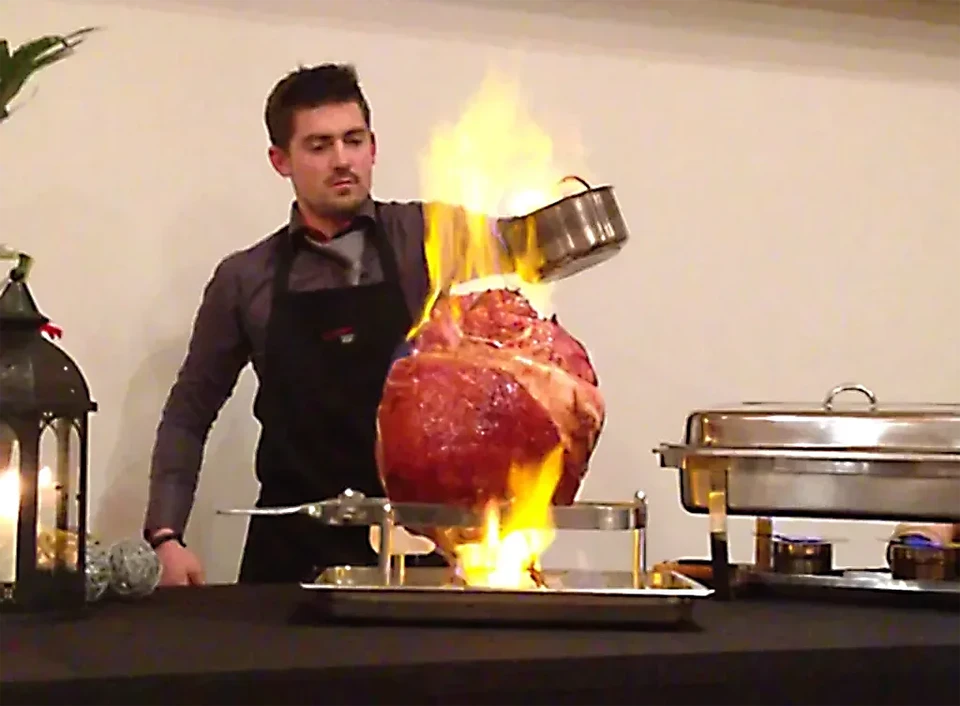 Le barman fait flamme sur un cocktail à l'écorce orange en gros plan