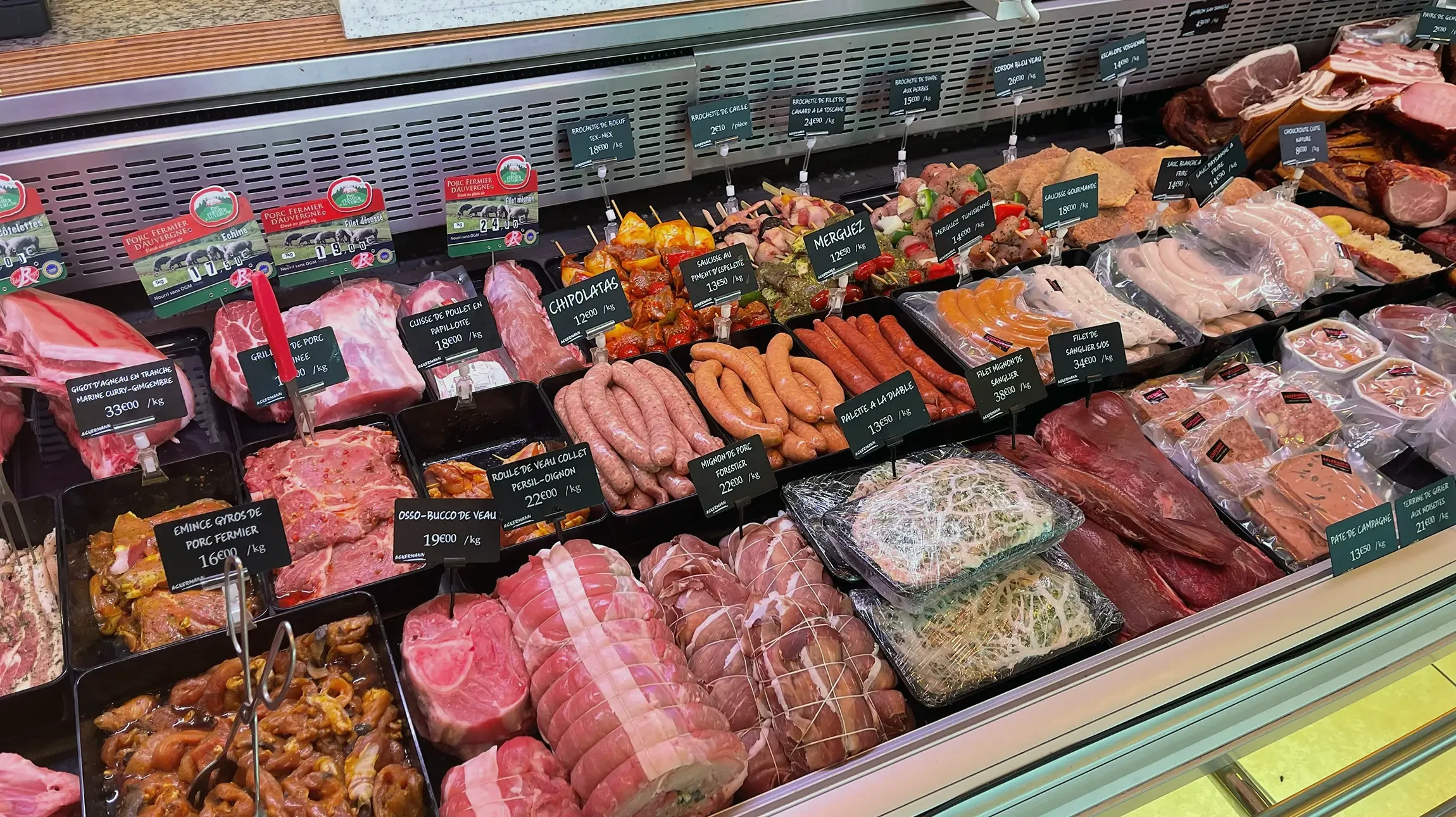 Présentation gastronomique d'amuse-bouches sur plateau noir : roulés de charcuterie italienne avec bâtonnets apéritifs, servis dans verres transparents avec garniture de roquette fraîche