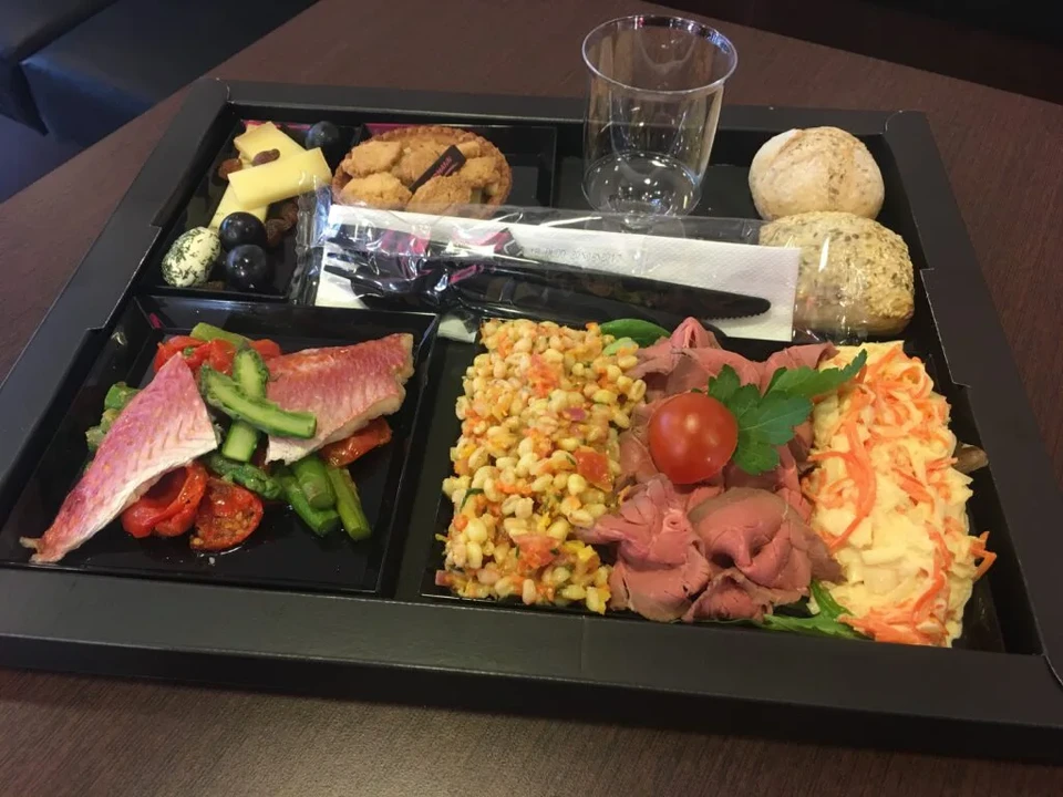 Chef en tenue professionnelle blanche finalise le dressage d'un plat gastronomique dans une cuisine de restaurant