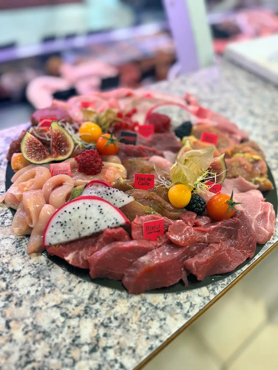 Préparation culinaire en intérieur, main tenant une part de tarte flambée alsacienne découpée sur planche d'ardoise noire